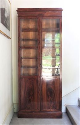 un grand meuble en bois avec des portes en verre dans une pièce