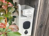 a white box with a black button on the side of a fence