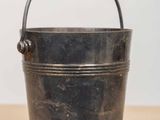 an old metal bucket sitting on top of a wooden table