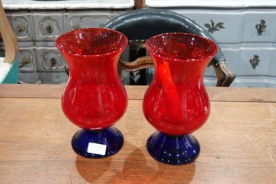 deux vases rouges et bleus posés sur une table en bois