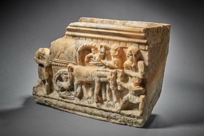 an ancient stone relief of a man and a woman on a cart