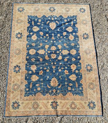 un tapis bleu et beige orné d'un motif floral