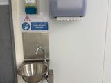 a sink and a hand dryer on the wall