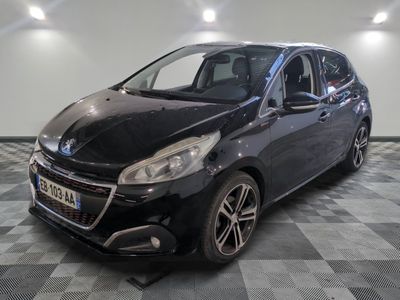la voiture noire est garée sur un sol en damier dans le garage