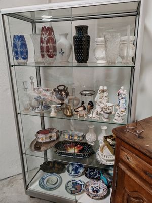 une vitrine en verre sur laquelle sont disposés de nombreux vases