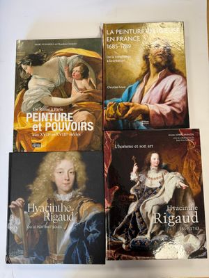 quatre livres posés sur une table, à côté d'un tableau représentant un homme et une femme
