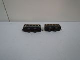 two small toy trains sitting on a white surface
