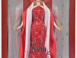 La poupée Barbie se trouve dans une boîte rouge avec une cape blanche.
