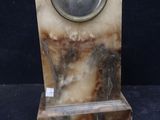 a marble clock on a stand with a glass bowl on top
