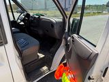 une camionnette blanche dont la porte est ouverte, garée sur le bord de la route