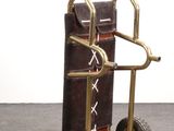 a small hand truck with luggage on it on the floor