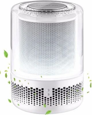 a white air purifizer with leaves flying around it