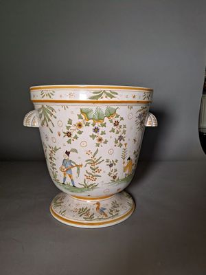 a white vase with a green and yellow design on it