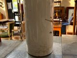 a white vase sitting on top of a table in a room