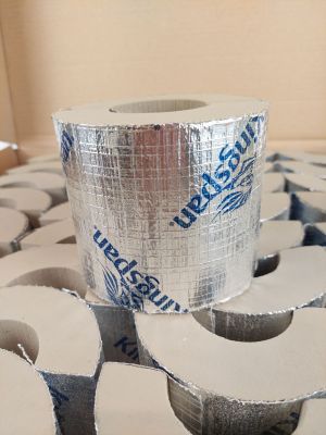 un rouleau de ruban adhésif posé sur une pile de rouleaux de papier toilette