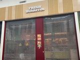 a store front with a red door and a sign on the side