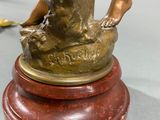 a bronze statue of a woman holding a dog