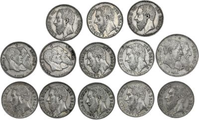 a close up of a bunch of silver coins on a white surface