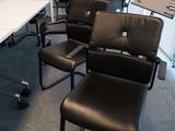une pièce avec des chaises et une table sur laquelle se trouve un ordinateur portable
