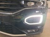a close up of the front of a car with its headlights turned on