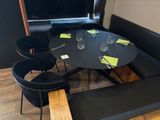 une table avec quatre chaises et un banc dans un coin de la pièce