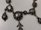 a close up of a necklace on a white surface
