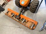 a tractor with a plow attached to it in a garage
