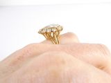 a woman ' s hand holding a gold ring with three diamonds