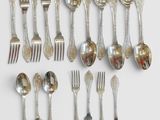 de nombreuses cuillères et fourchettes en argent disposées sur la table