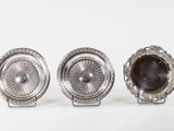 three silver plated objects on a white surface with a white background