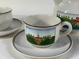 a tea pot and two cups on a saucer