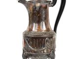 une cafetière en argent posée sur un support, sur fond blanc