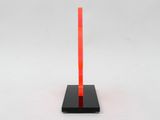 a red pole with a black base on a white surface