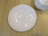 a white cup and saucer sitting on a wooden table