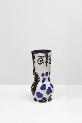 un vase blanc et bleu posé sur une table blanche