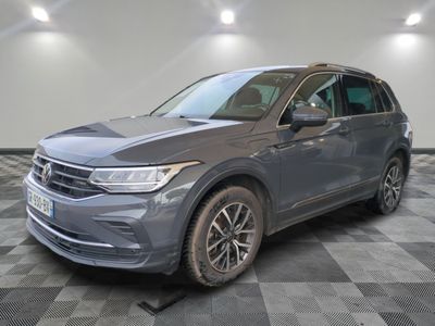 un SUV Volkswagen gris garé dans un garage au sol carrelé
