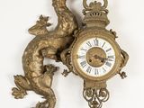 une horloge en or ornée d'un dragon, accrochée au mur
