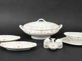 four pieces of white and orange china on a black background