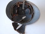 a dirty helmet with a knife stuck in it