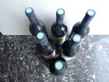several bottles of wine are lined up on a counter top