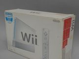 Console de jeux Nintendo Wii dans son emballage d'origine, posée sur une surface blanche avec un fond gris