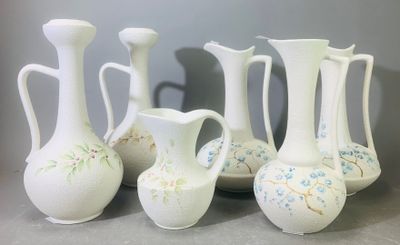 cinq vases blancs posés les uns à côté des autres sur une table