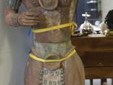 une statue représentant un homme debout à côté d'une table