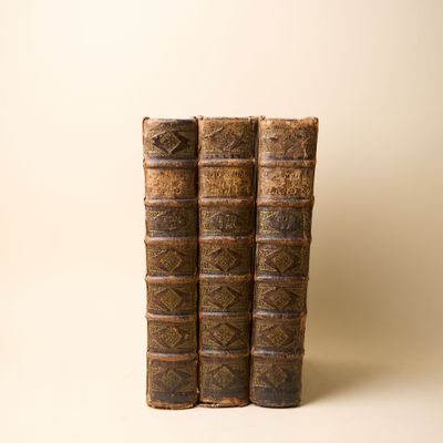 deux vieux livres posés l'un sur l'autre sur une surface blanche