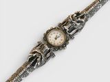 une image d'un gros plan d'une montre-bracelet sur une surface blanche