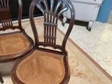 two wooden chairs sitting next to each other on a rug