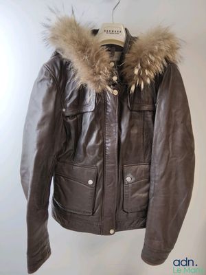 brown leather jacket with fur collar and cuffs hanging on a hanger