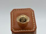 brown leather box with a gold ring on top of it