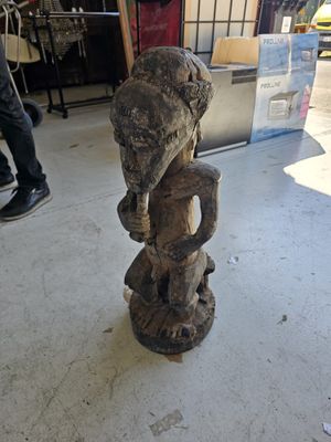 a statue of an elephant that is sitting on top of a stump