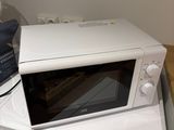 un micro-ondes posé sur une machine à laver et un sèche-linge